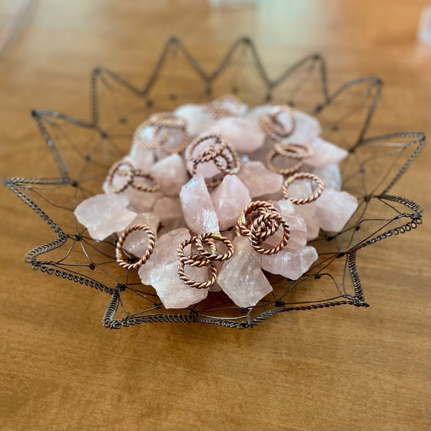 tensor ring finger rings in a wire basket with rose quartz crystals
