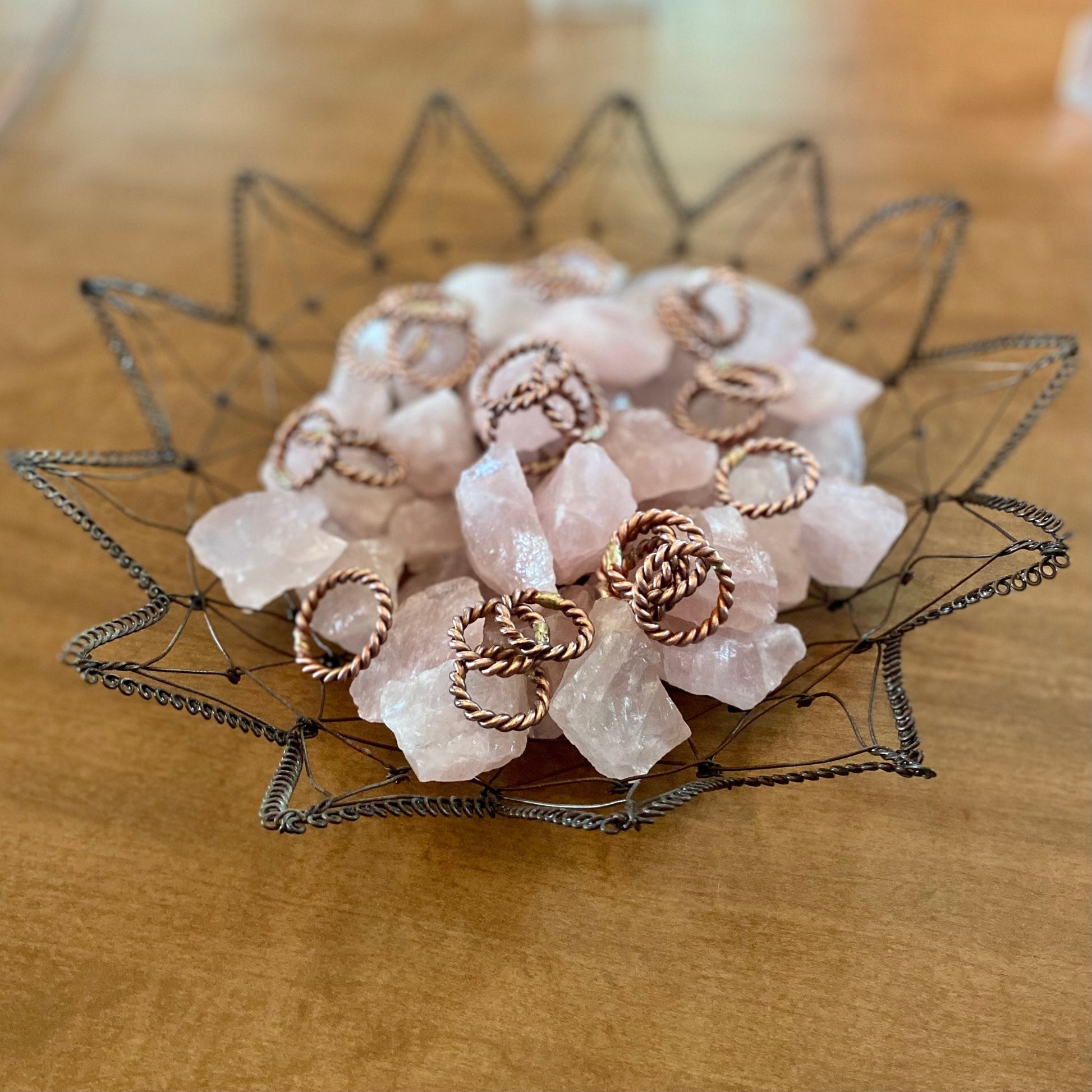 tensor ring finger rings in a wire basket with rose quartz crystals